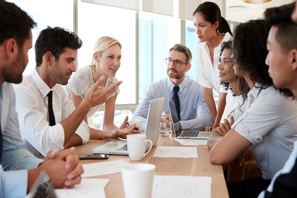Business professionals participating in a collaborative English training group meeting.