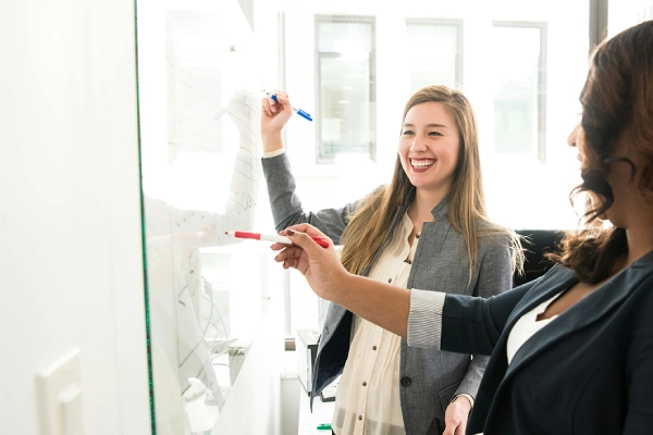 Personalized English coaching with a teacher and student working together at a whiteboard.
